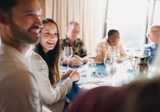 Group of guests talking at dinner table.