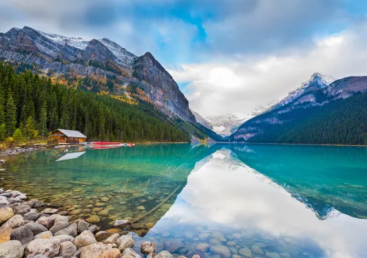 Large lake vista, wooden shack, mountains in background.