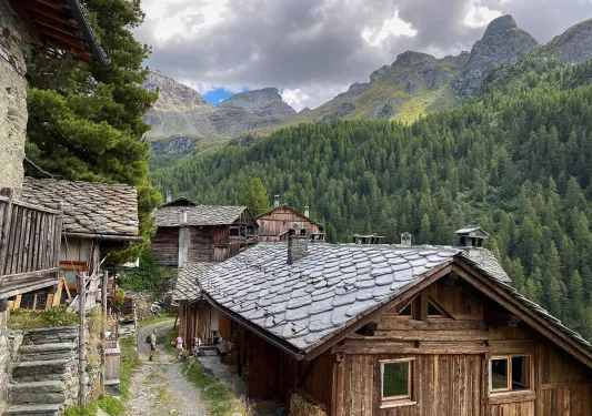 Shot of guests walking through mountain village, mountains all around.