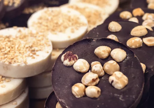 Close-up of chocolate pucks, nuts on top.