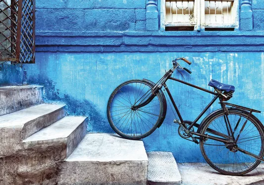 Bike sitting on the stairs against a blue wall