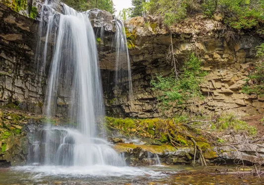 Shot of waterfall flowing into small lake.