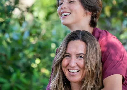 Two guests, one on the other's back, both smiling for camera.