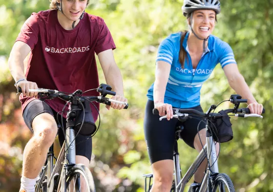 Two guests on bikes, cycling towards camera.