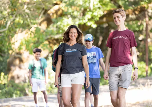 Group of guests walking on trail, one smiling at camera.