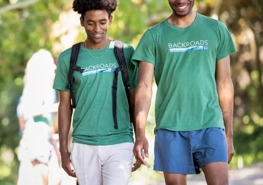 Two guests in BR gear, walking down trail.