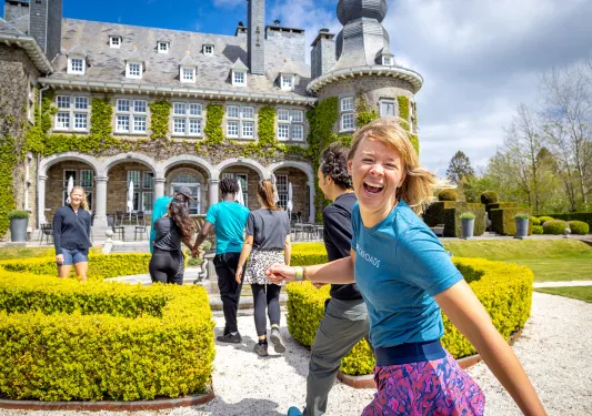 Guests walking towards stone building, one is smiling at camera.