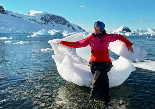 Woman sitting in a large piece of ice in Antarctica