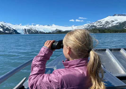 Child with binoculars on boat