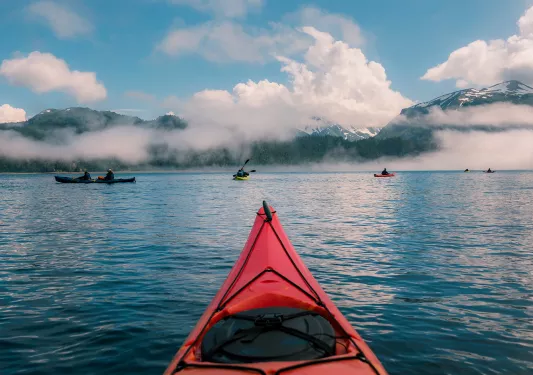 POV shot of guest kayaking, large lake, other guests, clouds etc.