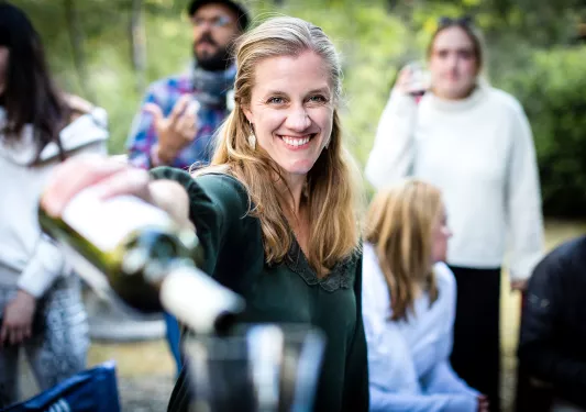 Point of view shot of woman pouring wine in a (your) glass.