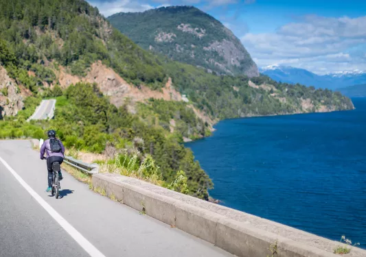 Solo biker riding along a lake in Argentina