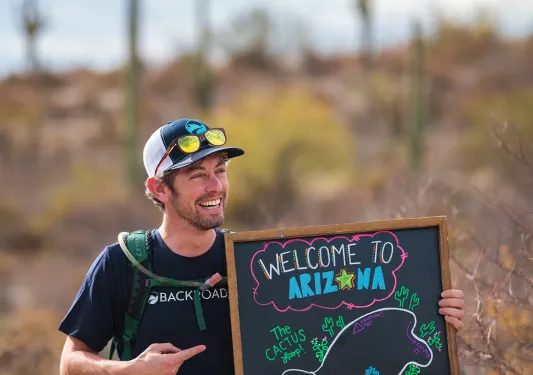 Leader holding a welcome to Arizona sign