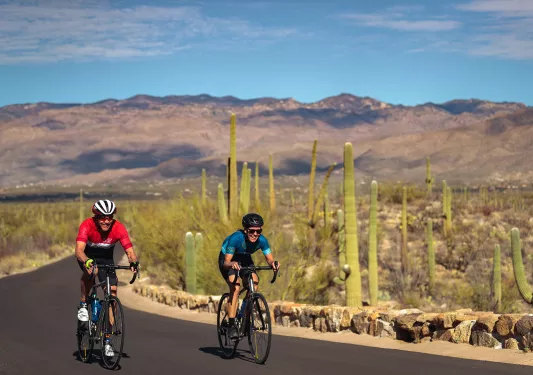 Biker wearing red, biker wearing blue, on road in AZ