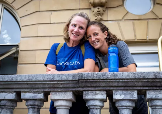 Two guests on stone balcony.