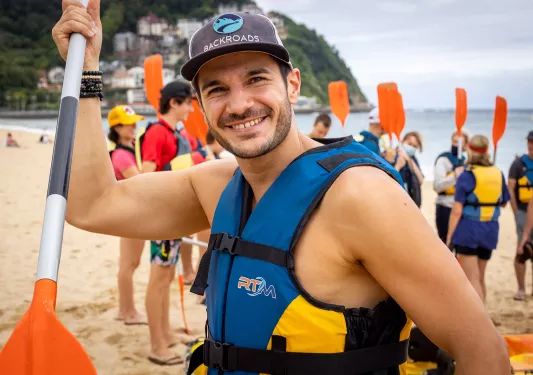 Close-up of leader in kayaking gear on beach.