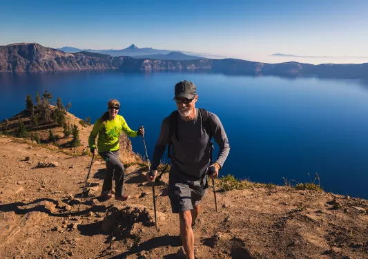 Two guests hiking along the rim of Crater Lake.
