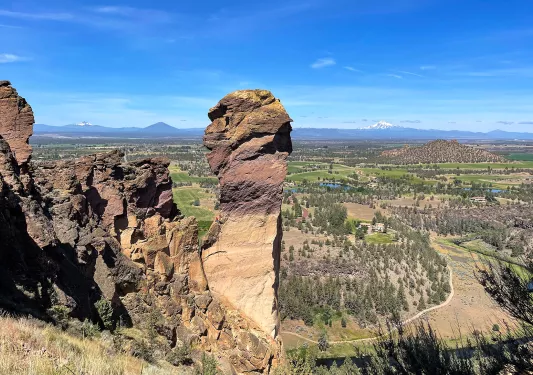 Wide shot of craggy mountain range, flat grassland in background.