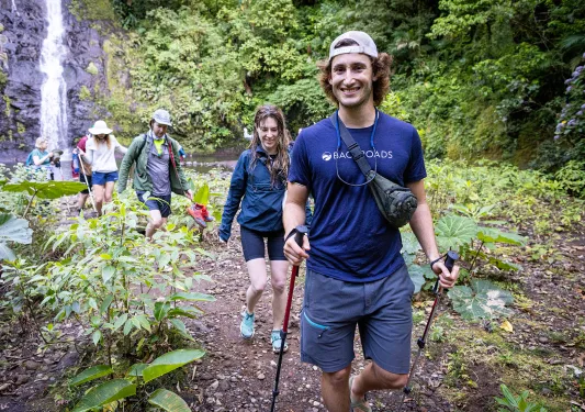 Leader Hiking Group Away From Waterfall