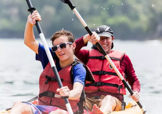 Two guests kayaking, paddling.