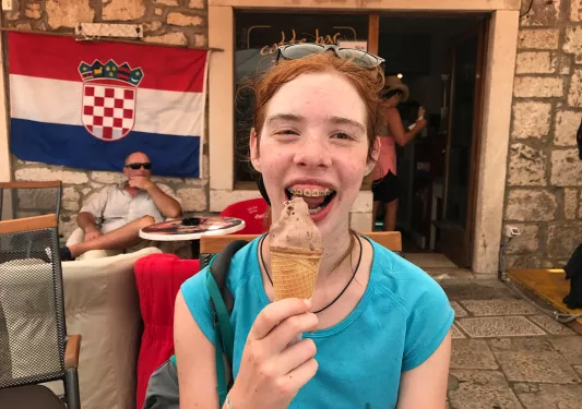 Young guest with ice cream cone, smiling at camera.