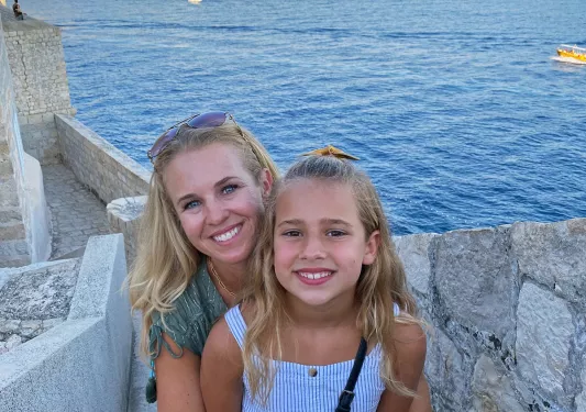 Two young guests on stone steps, ocean vista behind them.
