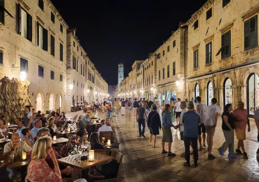 Shot of large group of people in European town during night time. 