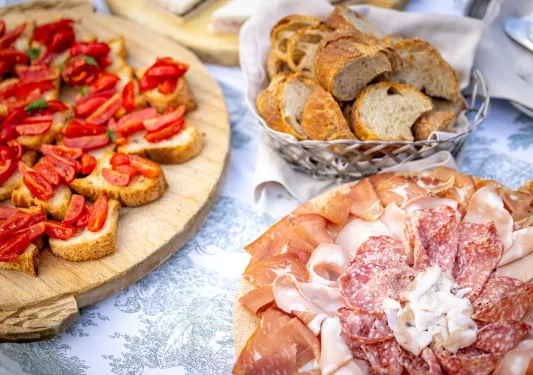 Platter of bread and tomatoes, cured meats, etc.