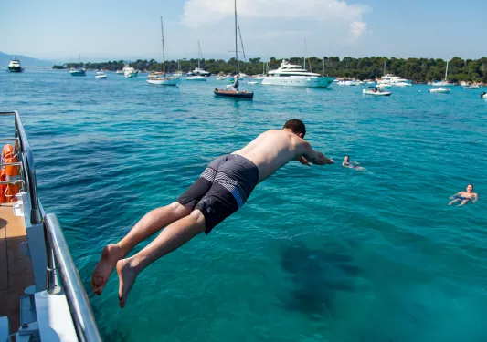 Backroads guest diving into the sea from the side of a boat