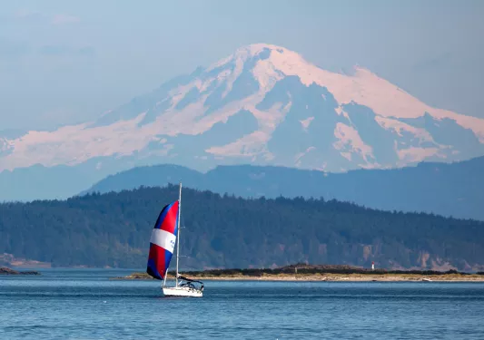 Wide shot of Mount Baker, small sailboat in foreground.
