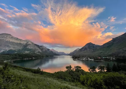 Orange sunset over lake and mountains