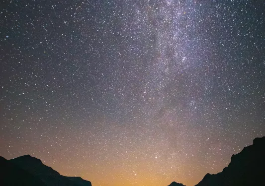 Sunset with eyepopping stars shining over mountains and lake
