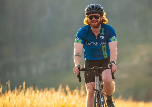 Backroads guest smiling while riding through golden fields
