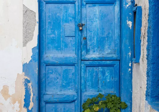 Close-up of blue door on white building.