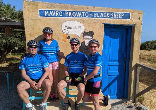 Four guests in biking gear at small rest point building. 