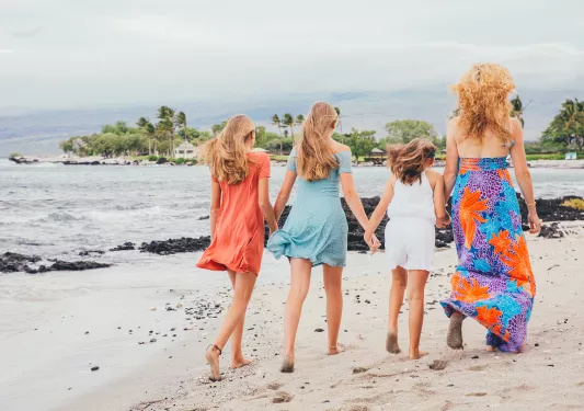 Mother a daughters walking along the beach in Hawaii