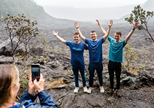 Guests posing for a photo in a lava field in Hawaii