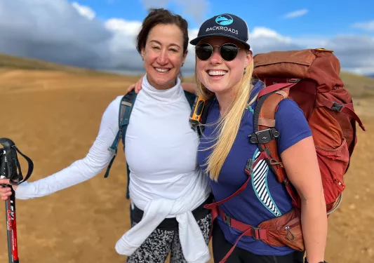 Two hikers hugging, posing for photo.