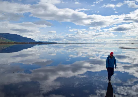 Hiker walking through glassy water