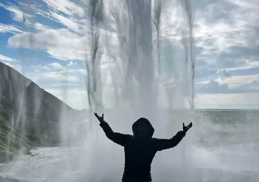Gust standing under waterfall