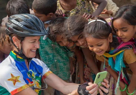 Woman showing her phone to children in India