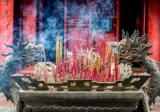 Incense burning in a dragon shaped shrine in Vietnam