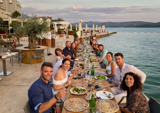 Guests at oceanside dinner. All looking towards camera.