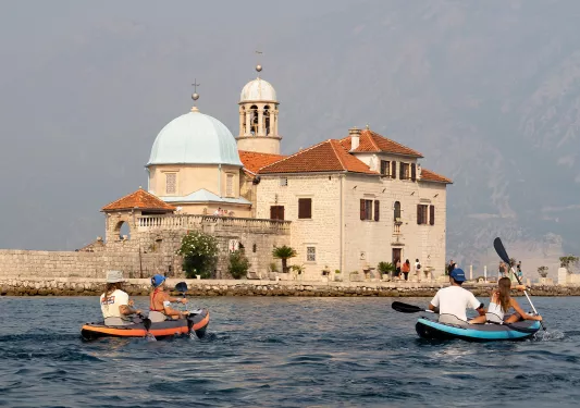 Four guests kayaking, Our Lady Of The Rocks, Montenegro in the distance.