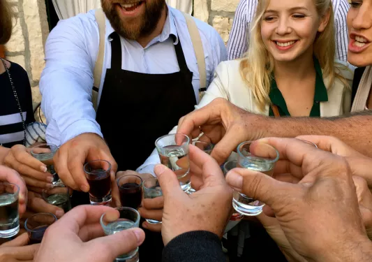Guests and locals cheersing shot glasses.