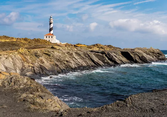 Rocky inlet, stripes lighthouse in distance.