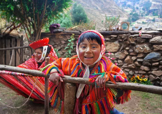Two locals in colorful garb, one looking at camera, smiling.