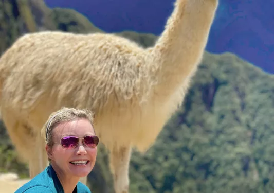 Guest posing in front of alpaca.