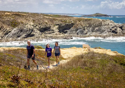 Hikers walking along a sandy path in Portugal