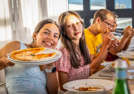 Teenagers eating handmade pizza in Portugal